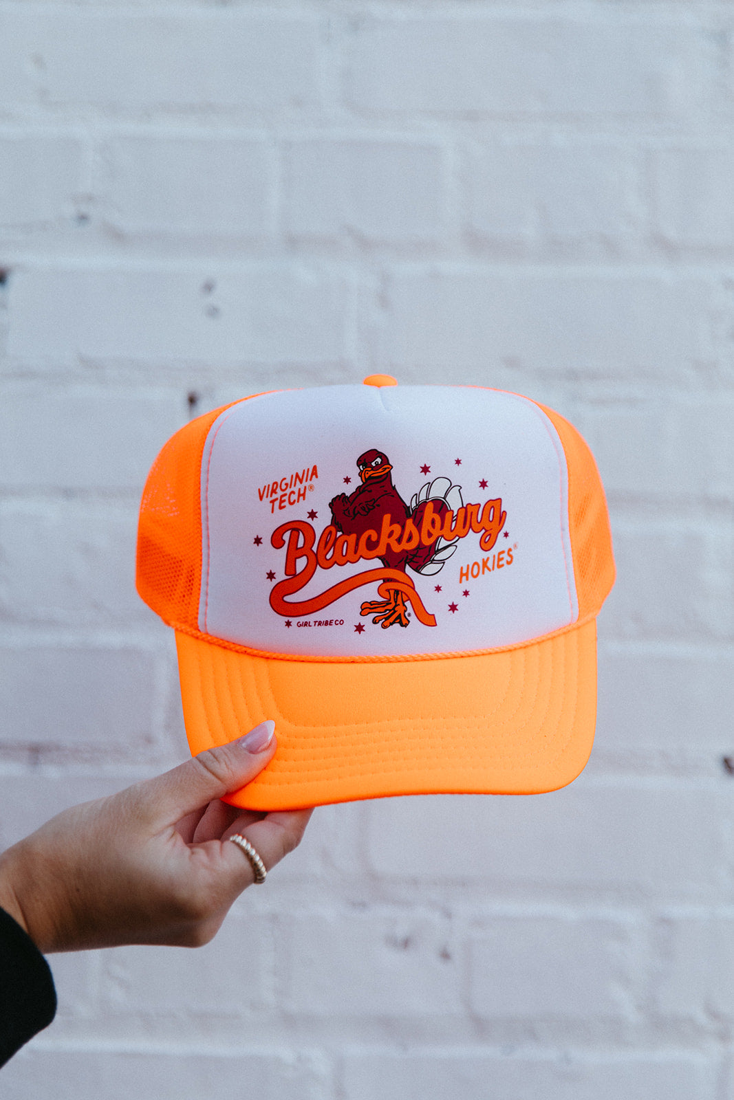 Show off your school spirit with the Virginia Tech: Blacksburg Trucker Hat! This stylish womens hat features the iconic Virginia Tech logo and is perfect for any avid fan. Stay cool and look cool with this trucker hat, the perfect addition to any game day outfit. Go Hokies!

Hat Brand: Otto

Color:&nbsp;White and Neon Orange

Girl Tribe Co. proudly&nbsp;designs, prints, embroiders,&nbsp;and&nbsp;ships&nbsp;all of our graphics in the Girl Tribe production facility in Charlotte, NC.&nbsp;