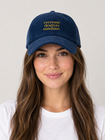 Model wearing the Everyone Deserves Sunshine corduroy hat, rivals-to-lovers hockey romance merch by Girl Tribe Co.